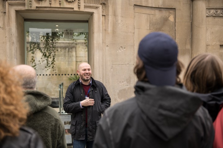 a person standing in front of a building talking on a cell phone