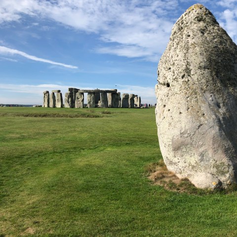 a large stone building with a grassy field