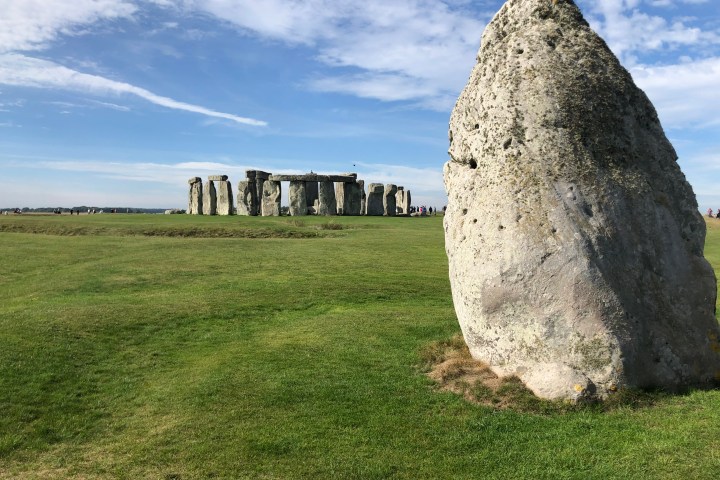 a large stone building with a grassy field
