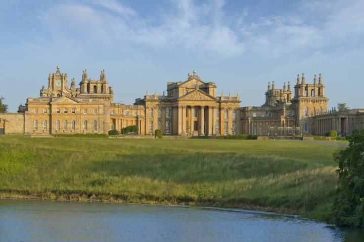 a castle surrounded by a body of water with Blenheim Palace in the background