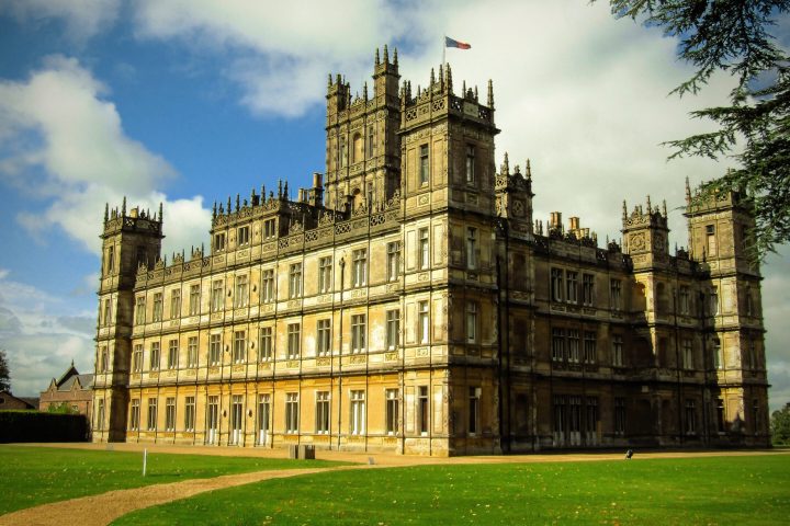 a large clock tower in front of Highclere Castle