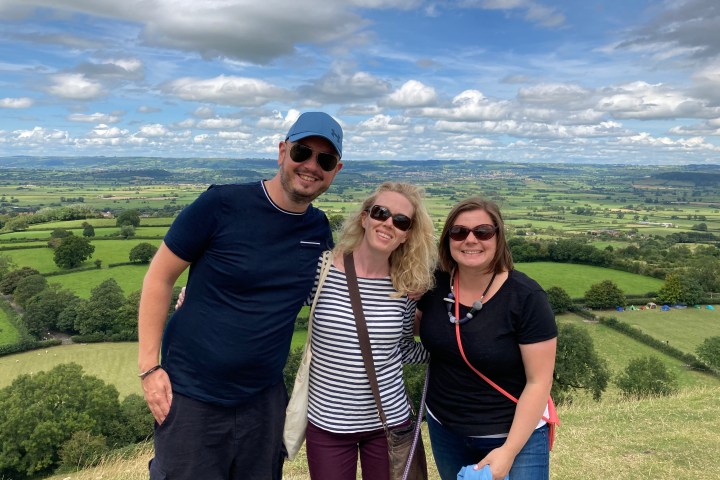 a man and a woman standing in front of a mountain