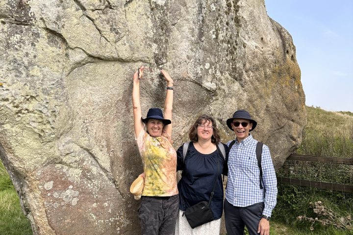 a group of people standing in front of a rock