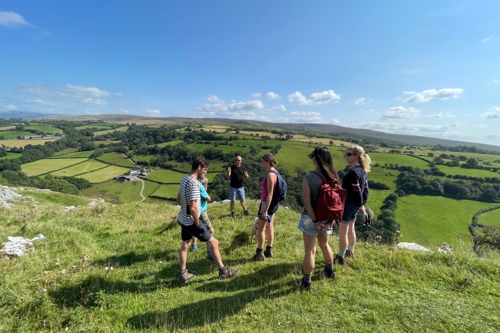 a group of people standing on a lush green field