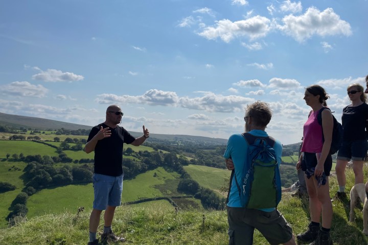 a group of people standing on a grassy hill