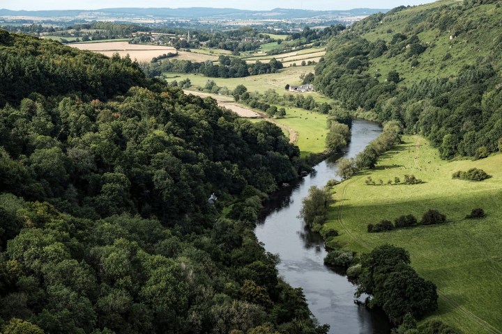 a river with a lush green hillside